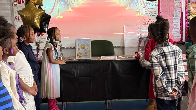 K-8 School in Roseville: Reach Charter Academy students premier their book.