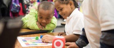 Buffalo United Charter School, K-8 School in Buffalo NY: two younger students playing a game with bear figures.