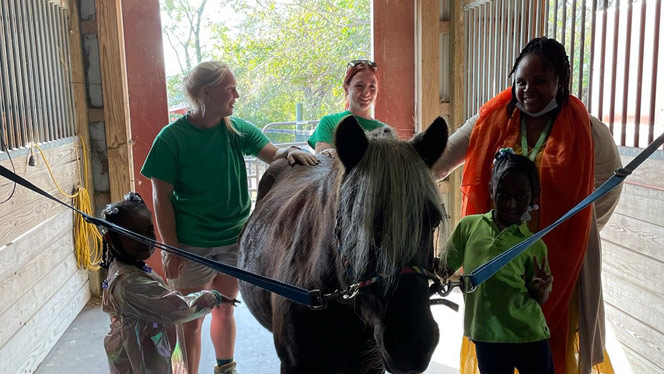 K-8 School in Cincinnati: Orion students petting a horse.