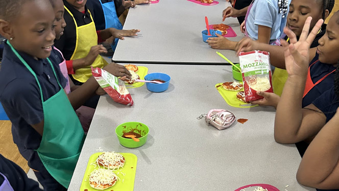 K-8 School in East Cleveland: Apex Academy students sitting at table eating snacks.