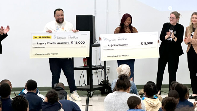 K-8 School in Detroit: Legacy staff hold up winning checks during assembly.