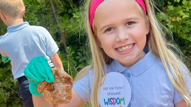 K-8 School in Matthews: Student picking up litter.