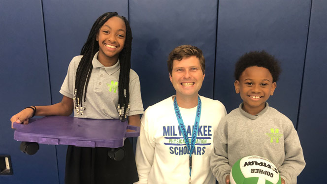 K-8 School in Milwaukee: Students pose for photo with PE teacher Anderson.