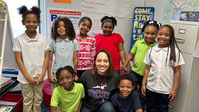 K-8 School in Flint MI: Cooley poses with students from her class.