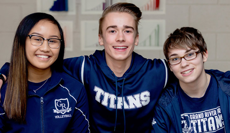 Two students smiling in front of their classroom lockers
