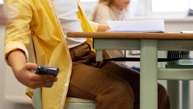 High School in Grand Rapids: Student on phone in classroom.