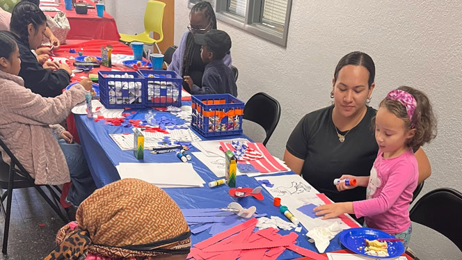 K-8 School in Winston-Salem: Children paste together pieces of paper into American flags.