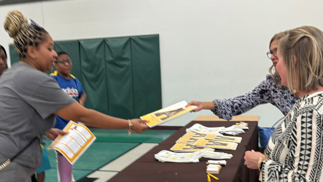 K-8 School in Dayton: Parent talking with representative at booth.