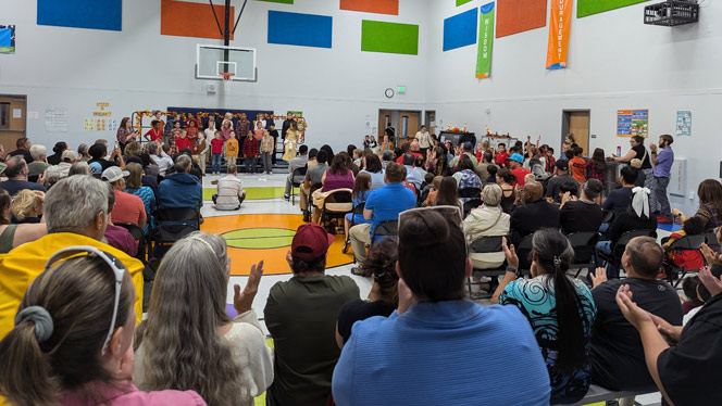 K-8 School in Colorado Springs: Students singing in front of group of families.