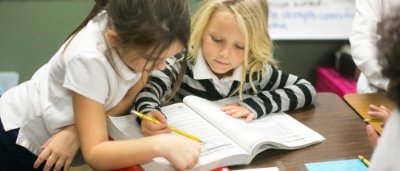 Two students completing work in classroom