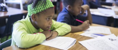 K-8 School in Detroit: Students working on worksheet at desk.