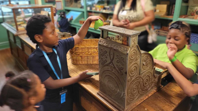 K-8 School in Detroit: Detroit Premier lower elementary students use a cash register.