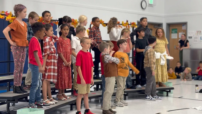 K-8 School in Colorado Springs: Students singing on stage in gymnasium.