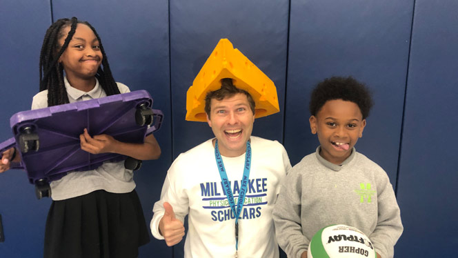 K-8 School in Milwaukee: Students pose for photo with PE teacher Anderson.