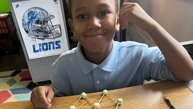 K-8 School in Detroit: Detroit Merit student smiles with snowflake design.