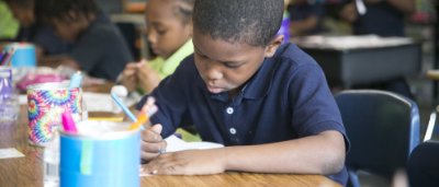 K-8 School in Detroit: Student working on assignment at desk.